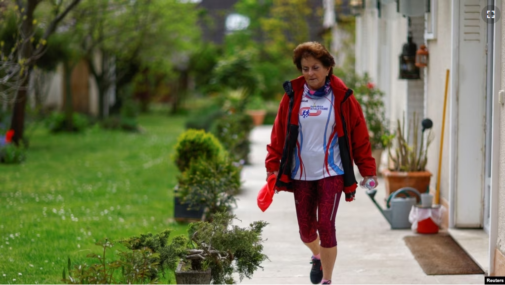 Barbara Humbert, 83, long-distance world record winner in her category who dreams to run the Olympic Marathon For All at the Paris 2024 Olympics and Paralympics Games, walks in the garden of her house in Eaubonne near Paris, France April 26, 2023. (REUTERS/Gonzalo Fuentes)