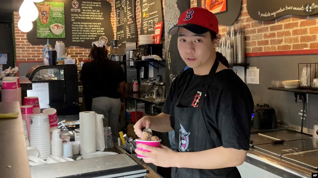 Christopher Au, 19, dishes out ice cream at a J.P. Licks in Boston’s Beacon Hill neighborhood on Thrusday, May 25, 2023. (AP Photo/Steve LeBlanc)