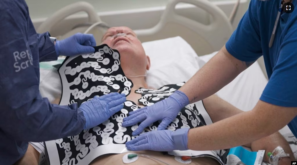 In this photo provided by Washington University, Jeff Backus is fitted with a vest of electrodes in St. Louis on Tuesday, Feb. 7, 2023.(Huy Mach/Washington University, St. Louis via AP)