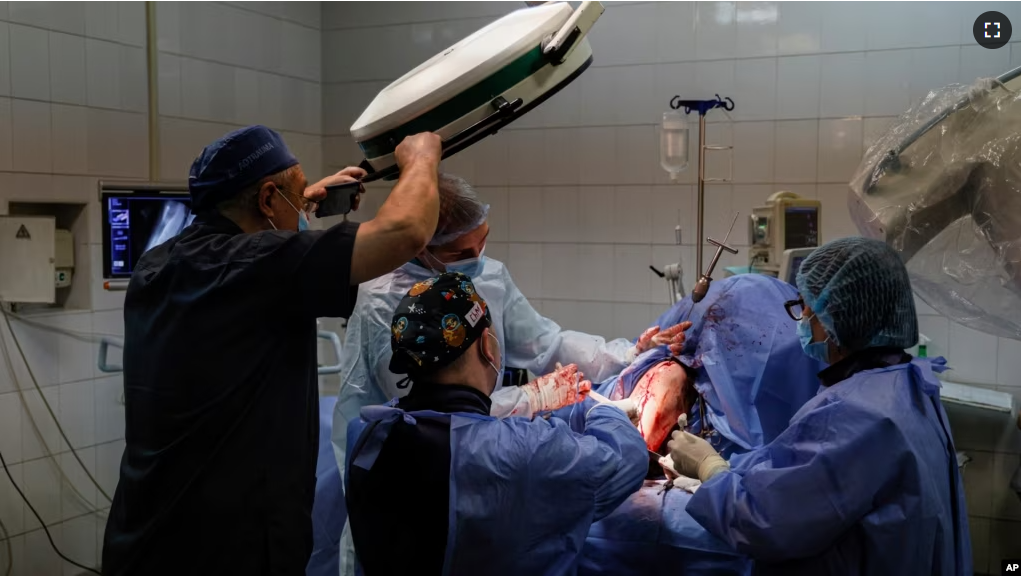 Petro Nikitin, left, takes part a surgery operation of Ukrainian serviceman at the military hospital in Kyiv, Ukraine, on Thursday, May 5, 2023. (AP Photo/Alex Babenko)