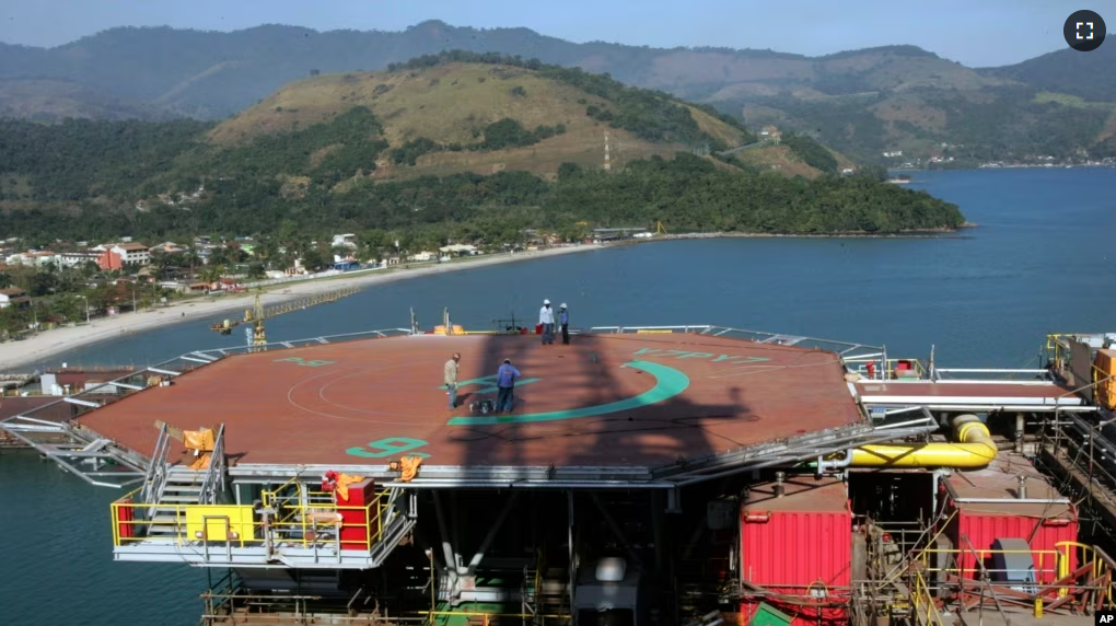 FILE - Petrobras workers walk on platform 51 "Majuro" in Angra dos Reis, Brazil, Aug. 21, 2008. (AP Photo/Ricardo Moraes, File)