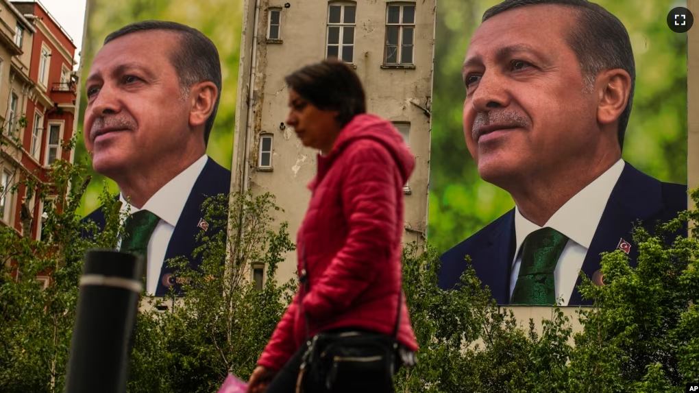 A person walks past billboards of Turkish President and People's Alliance's presidential candidate Recep Tayyip Erdogan a day after the presidential election day, in Istanbul, Turkey, Monday, May 15, 2023. (AP Photo/Emrah Gurel)