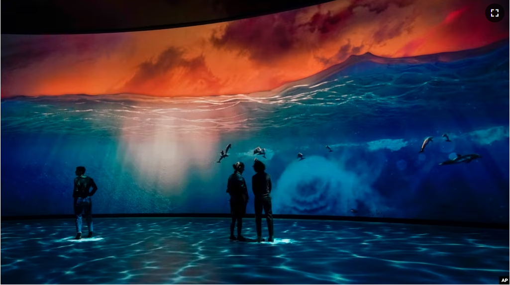 FILE - Visitors take in the Invisible Worlds interactive display during a media preview of the Richard Gilder Center for Science, Education and Innovation, Wednesday, April 26, 2023, at the American Museum of Natural History in New York. (AP Photo/Mary Altaffer)