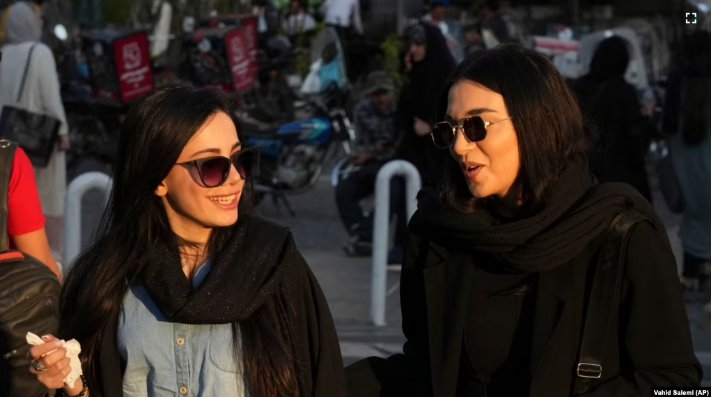 Women talk as they walk around Tajrish commercial district without wearing their mandatory Islamic headscarf in northern Tehran, Iran, Saturday, April 29, 2023. AP Photo/Vahid Salemi)