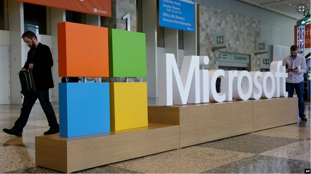 FILE - A man walks past a Microsoft sign set up for the Microsoft BUILD conference, April 28, 2015, at Moscone Center in San Francisco. (AP Photo)