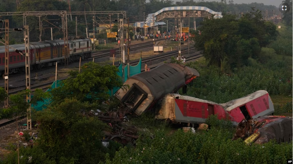 A passenger train passes by the site where two passenger trains derailed Friday in Balasore district, in the eastern Indian state of Orissa, Monday, June 5, 2023. (AP Photo/Rafiq Maqbool)