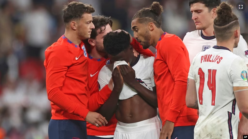 England players comfort teammate Bukayo Saka during the Euro 2020 soccer championship final match between England and Italy at Wembley stadium in London, Sunday, July 11, 2021.(Carl Recine/Pool Photo via AP, File)