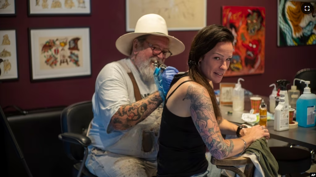 FILE - Henk Schiffmacher's needle whirrs as he tattoos the lines of am elephant on Lilian Rachmaran's back in Amsterdam, Monday, June 19, 2023. (AP Photo/Peter Dejong)