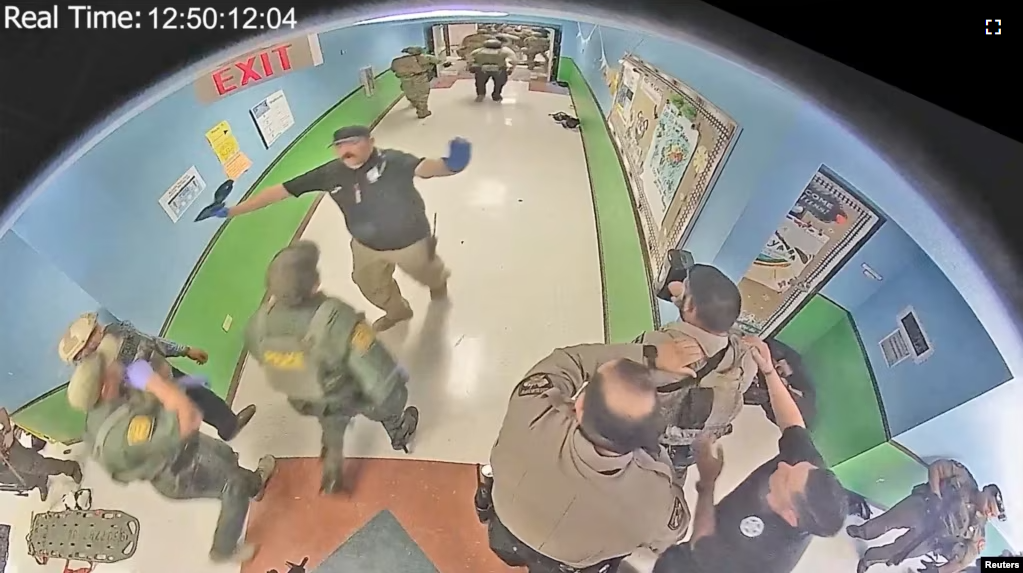 Law enforcement officers stage in a hallway after Salvador Ramos entered Robb Elementary school to kill 19 children and two teachers in Uvalde, Texas, U.S. May 24, 2022 in a still image from surveillance video.