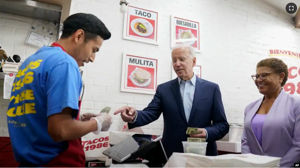 FILE - President Joe Biden, joined by Rep. Karen Bass, D, Calif., pays for a takeout order at Tacos 1986, a Mexican restaurant, in Los Angeles, Thursday, Oct. 13, 2022. (AP Photo/Carolyn Kaster)