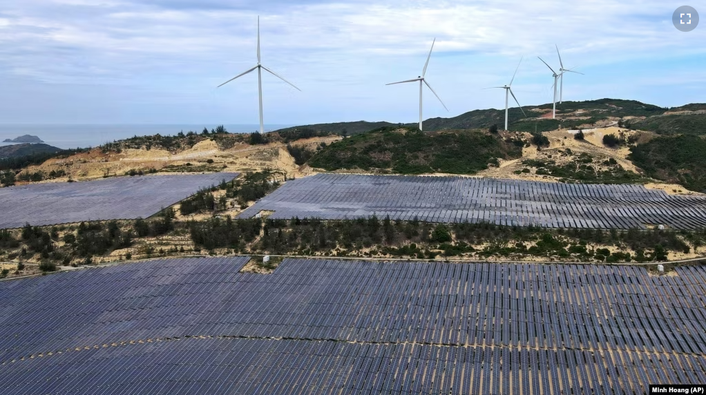 Solar panels work near wind turbines in Quy Nhon, Vietnam on June 11, 2023. Vietnam has released a long-anticipated energy plan meant to take the country through the next decade and help meet soaring demand while reducing carbon emissions. (AP Photo/Minh Hoang)