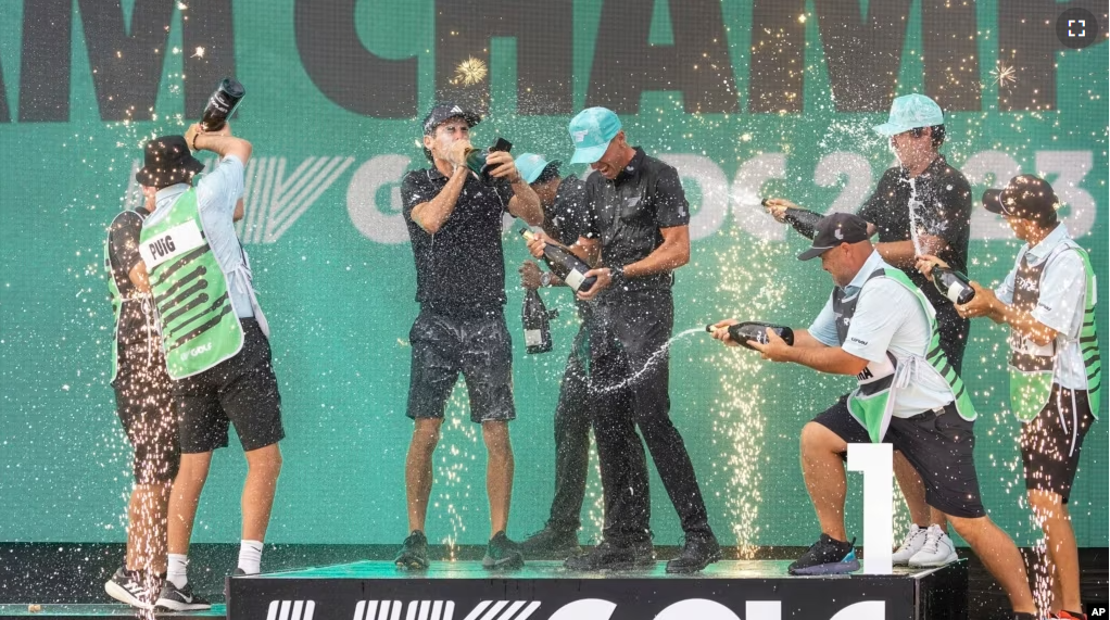 FILE - Team champions David Puig, Sebastián Muñoz, Mito Pereira, Captain Joaquín Niemann of Torque GC and their caddies celebrate on stage May 28, 2023, in Sterling, Virginia.