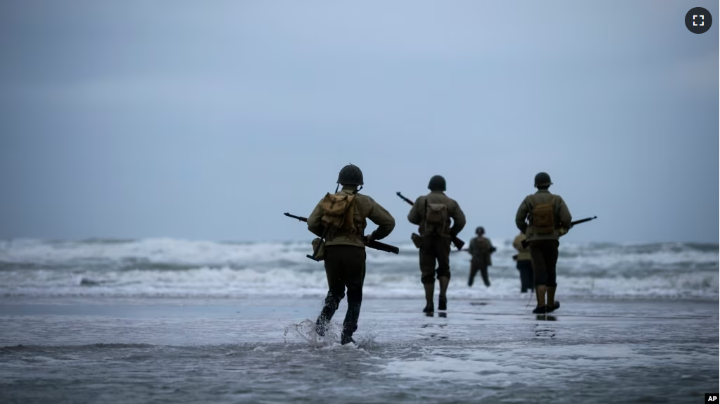 World War II reenactors walk on Omaha Beach in Saint-Laurent-sur-Mer, Normandy, France, Tuesday, June 6, 2023. Nearly 160,000 Allied troops landed on the shores of Normandy at dawn on June 6, 1944.
