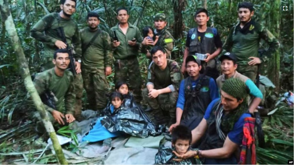 In this photo released by Colombia's Armed Forces Press Office, soldiers and Indigenous men pose for a photo with the four Indigenous brothers who were missing after a deadly plane crash, in the Solano jungle, Caqueta state, Colombia, June 9, 2023.