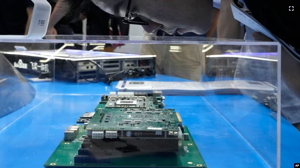 A visitor examines a computer chipset at the booth for Chinese semiconductor and chip developer Kunlunxin during the World AI Conference in Shanghai, Wednesday, July 5, 2023. (AP Photo/Ng Han Guan)