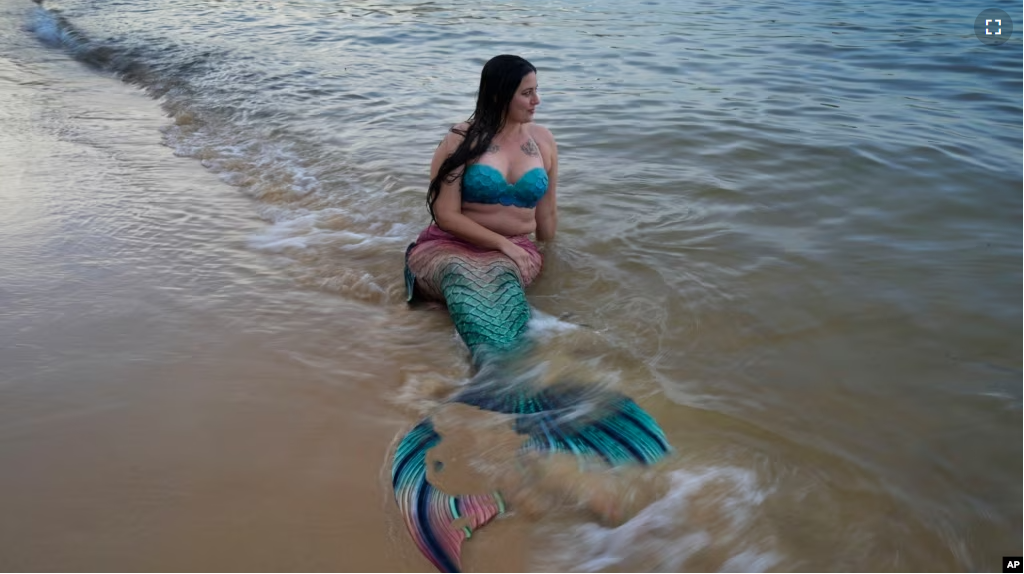 FILE - Lauren Metzler prepares for a swim at Manly Cove Beach in Sydney, Australia, Thursday, May 26, 2022. Mermaid does not have to worry about sink or swim. (AP Photo/Mark Baker)