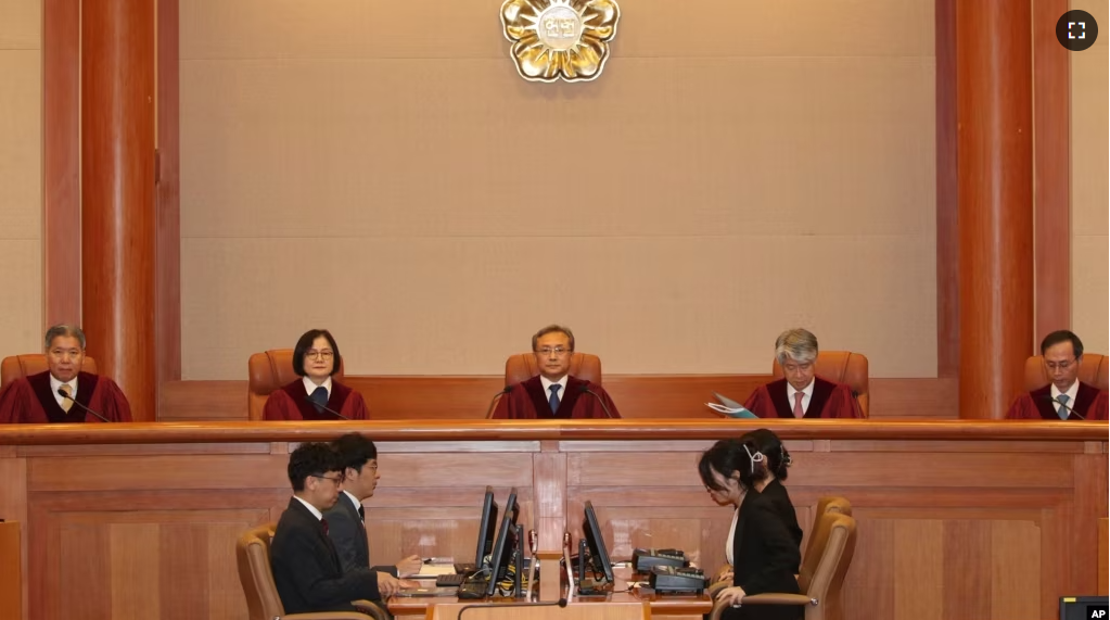 South Korea's Constitutional Court Chief Justice Yoo Nam-seok, top center, and other judges sit before the judgment at the Constitutional Court in Seoul, South Korea, Tuesday, July 25, 2023. (Yonhap via AP)