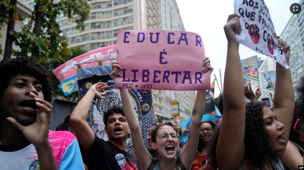 FILE - A student holds a sign that reads in Portuguese "To Educate is Freedom" during a protest against the budget cuts by President Jair Bolsonaro´s government of public schools and universities, in Rio de Janeiro, Brazil, Tuesday, Oct. 18, 2022. (AP Photo/Silvia Izquierdo)