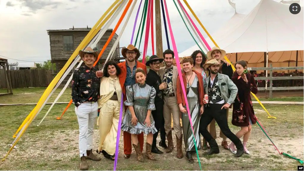 Wedding guests who adhered to the dress code of "Space Disco Cowboy," pose at a wedding in Austin, Texas on March 30, 2019. More than ever, wedding guests are contending with nontraditional dress code requests. (Rikki Gotthelf via AP)