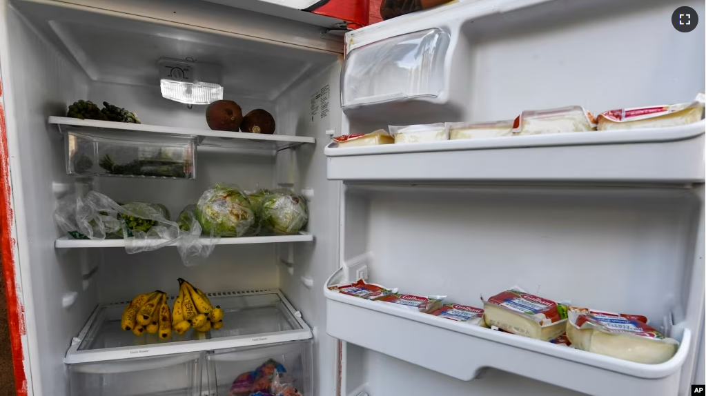 FILE - A Free Food Fridge Albany sidewalk refrigerator is stocked with produce and other food, June 25, 2021, in Albany, N.Y. The nonprofit Free-Go has put refrigerators and food storage centers in Geneva, Switzerland so people can get food. (AP Photo/Hans Pennink)