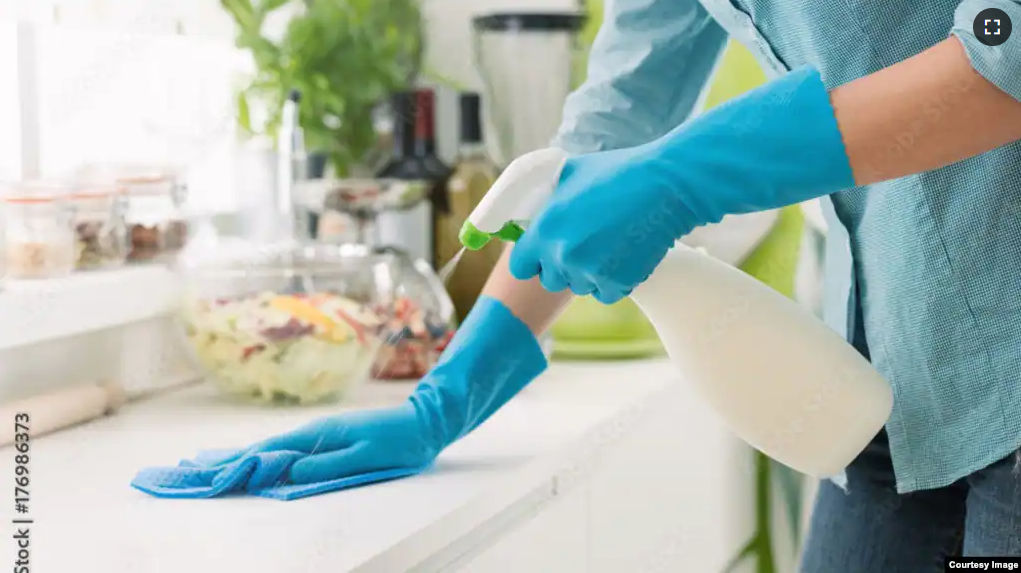 FILE - A person cleans a counter with a spray cleaner. (Adobe)