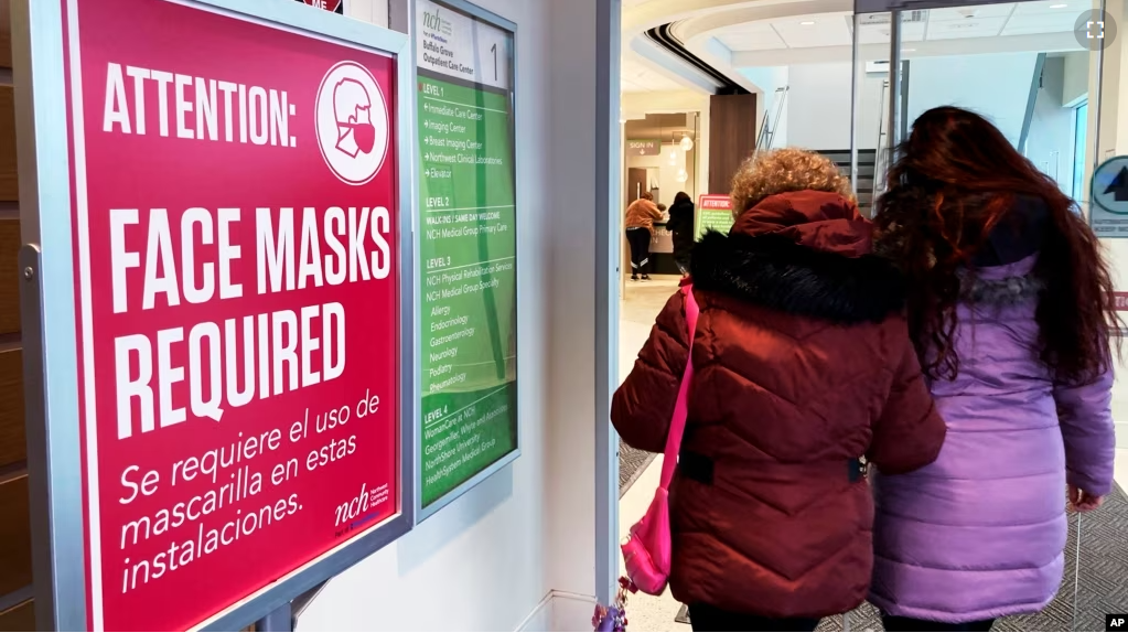 FILE - A sign announcing a face mask requirement is displayed at a hospital in Buffalo Grove, Ill., on January 13, 2023. (AP Photo/Nam Y. Huh)