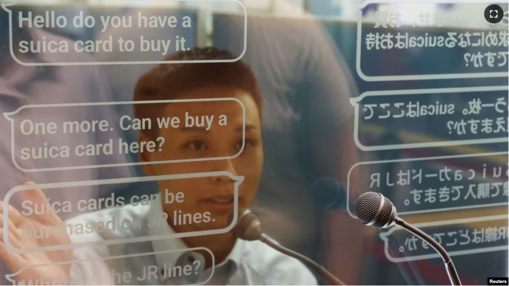 A staff of Seibu Railway uses an automated translation window to communicate with Austrian tourist Georg Riedlbaur (not in the picture) at the Seibu-Shinjuku station in Tokyo, Japan, July 26, 2023. (REUTERS/Kim Kyung-Hoon)