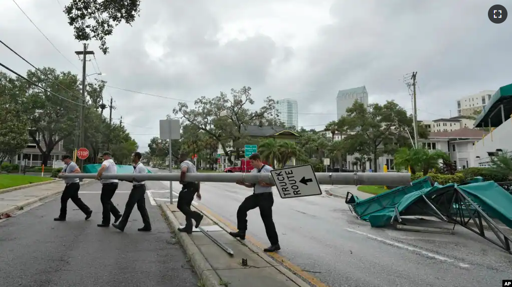 Members of the Tampa Fire Rescue Dept., remove a street pole brought down during Hurricane Idalia Wednesday, Aug. 30, 2023, in Tampa, Florida. (AP Photo/Chris O'Meara)