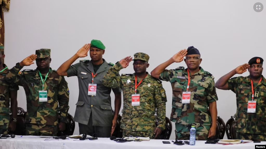 Military personnel gesture as the ECOWAS anthem is played during a meeting of the Committee of Chiefs of Defense staff on the deployment of the ECOWAS standby force in the Republic of Niger, in Accra, Ghana. August 17, 2023. (REUTERS/Francis Kokoroko)