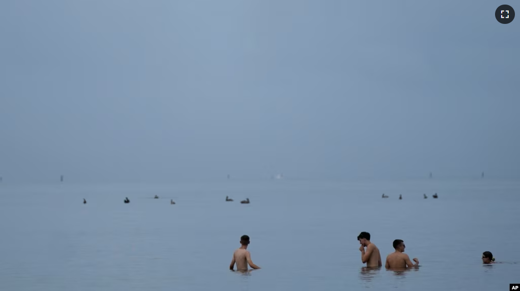 FILE - People swim in the ocean off of Crandon Park, July 28, 2023, in Key Biscayne, Fla (AP Photo/Rebecca Blackwell, File)