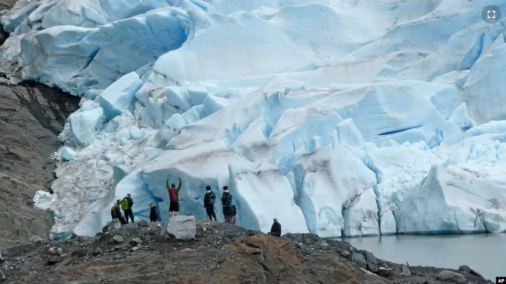 People take in the views of the Mendenhall Glacier on June 8, 2023, in Juneau, Alaska. As the Mendenhall Glacier continues to recede, tourists are flooding into Juneau. (AP Photo/Becky Bohrer)