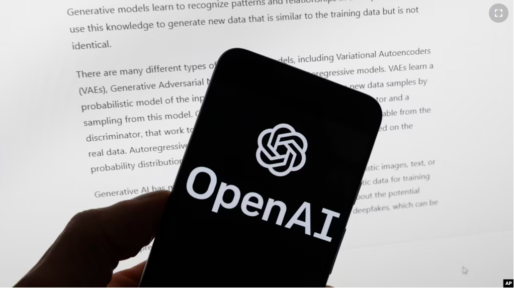 The OpenAI logo is seen on a mobile phone in front of a computer screen displaying output from ChatGPT, March 21, 2023, in Boston. (AP Photo/Michael Dwyer, File)