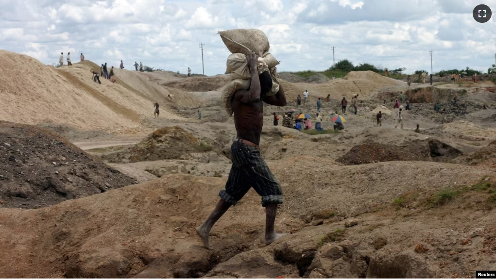 FILE - A Congolese man carries bags of copper and cobalt ore at an open-pit mine just outside of Lubumbashi in this February 3, 2006 photo. (REUTERS/David Lewis/Files)