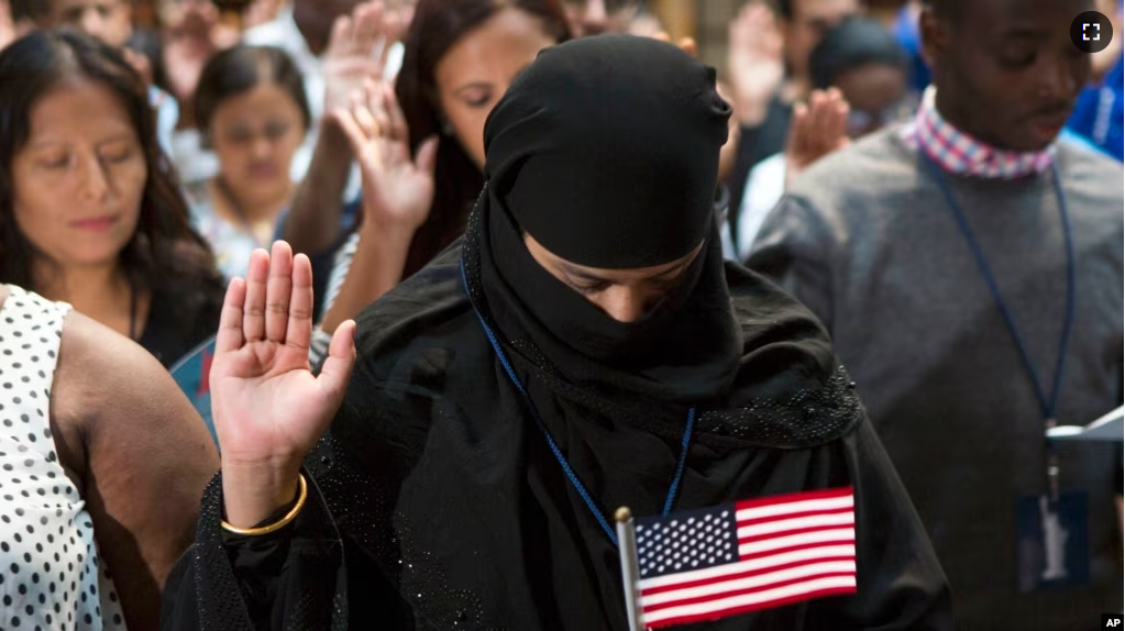 FILE - A participant from Bangladesh takes the Naturalization Oath of Allegiance to the United States of America, on June 30, 2017, during a naturalization ceremony at the New York Public Library in New York. (AP Photo/Michael Noble Jr.)