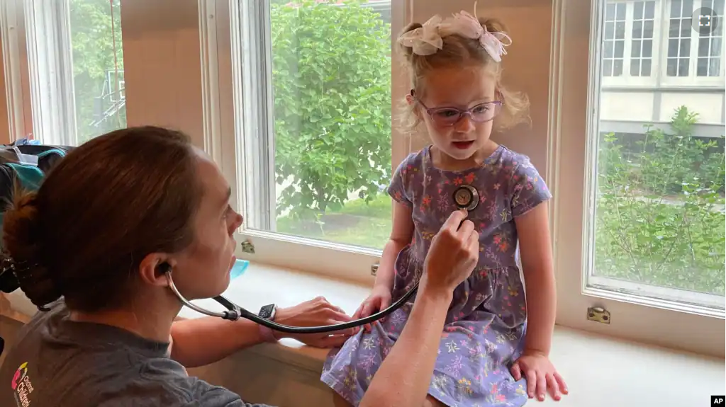 Courtney Chase, a nurse at Cincinnati Children's Hospital Medical Center, listens to 4-year-old Brynn Schulte's heart before the girl gets an infusion of medication to treat a rare genetic bleeding disorder, Aug. 3, 2023, in Cincinnati, Ohio. (AP Photo/Laura Ungar)