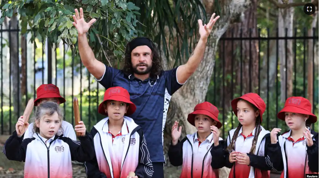 Educator Clark Webb performs a song with children including his daughter Jayalaani, at the Gumbaynggirr Giingana Freedom School, a bilingual school teaching the Gumbaynggirr language, in Coffs Harbour, Australia June 1, 2023. (REUTERS/Alasdair Pal)