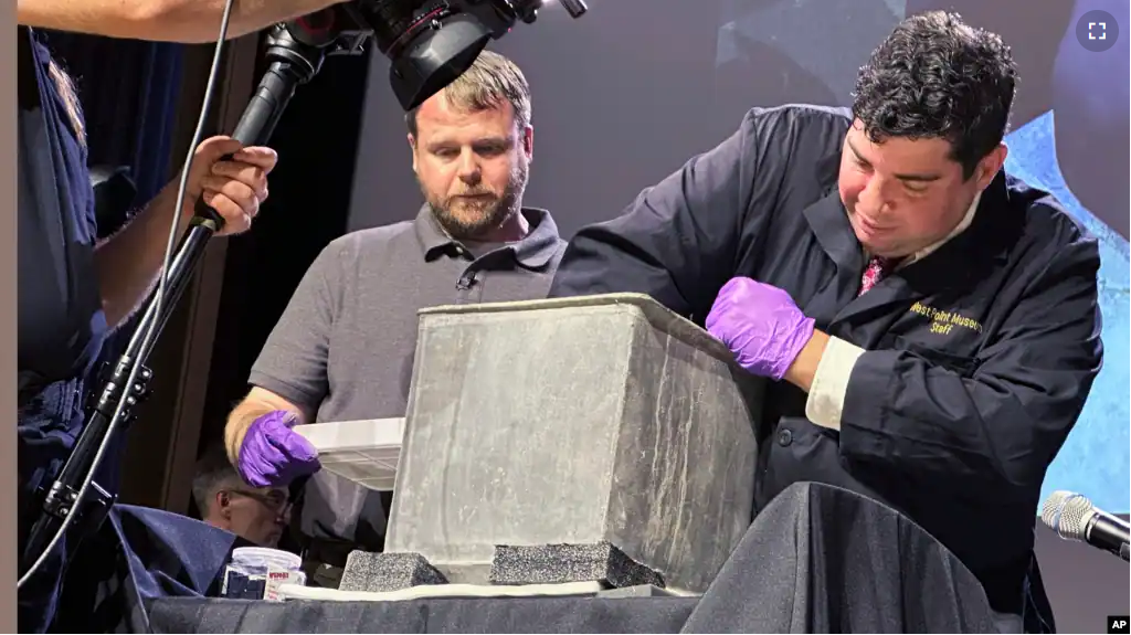 Paul Hudson, left, and Michael Diaz take part in the opening of a lead box believed to have been placed in the base of a monument almost two centuries ago, at the U.S. Military Academy, on Aug. 28, 2023, in West Point, N.Y. (AP Photo/Michael Hill)