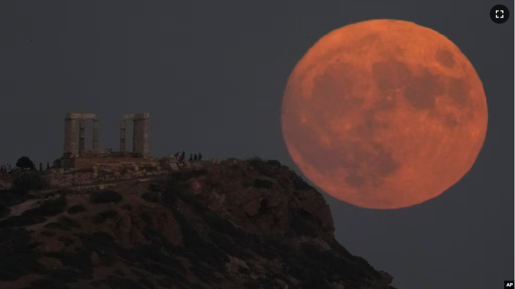 The supermoon rises behind the ancient temple of Poseidon at Cape Sounion, about 70 kilometers (45 miles) south of Athens, Greece, Wednesday, Aug. 30, 2023. (AP Photo/Thanassis Stavrakis)