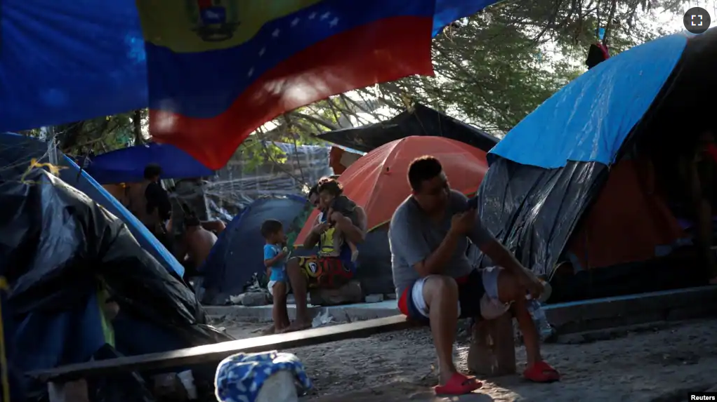 FILE - Venezuelan asylum seekers wait while they attempt to cross into the U.S. by an appointment through the Customs and Border Protection app, called CBP One, at a makeshift camp, in Matamoros, Mexico June 20, 2023. (REUTERS/Daniel Becerril)