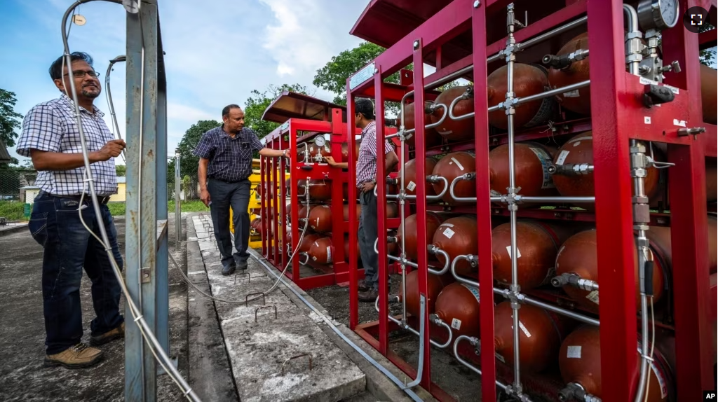 P V R Murthy, center, general manager at Oil India Limited, pump station 3, shows a part of a hydrogen plant in Jorhat, India, Thursday, Aug. 17, 2023. (AP Photo/Anupam Nath)