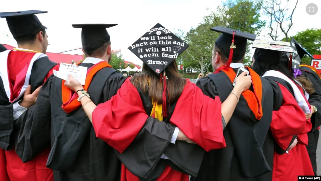 FILE - In this May 15, 2016 file photo, students embrace as they arrive for the Rutgers graduation ceremonies in Piscataway, New Jersey. (AP Photo/Mel Evans)