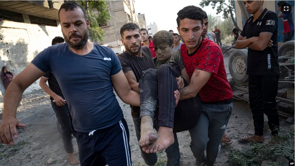 Palestinians carry a person wounded in Israeli airstrikes in Khan Younis, Gaza Strip, Monday, October 16, 2023. (AP Photo/Fatima Shbair)