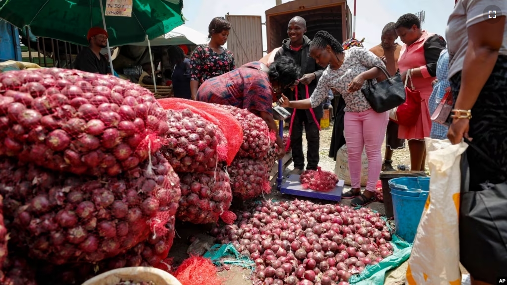 People buy onions at an open market in Nairobi, Kenya Tuesday, Sept. 12, 2023. (AP Photo/Brian Inganga)