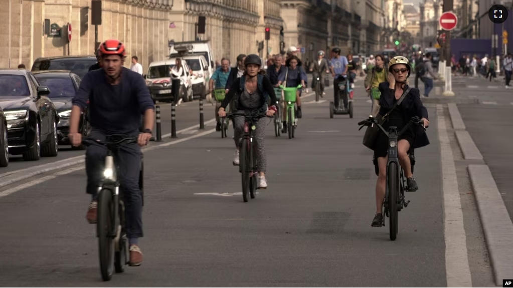 People ride on Rivoli street in Paris, Wednesday, Sept. 13, 2023. (AP Photo/John Leicester)