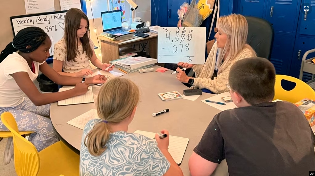 Piedmont math teacher Cassie Holbrooks helps a small group of fourth-grade students with a math problem in Piedmont, Ala., on Aug. 31, 2023. (Trisha Powell Crain/AL.com via AP)