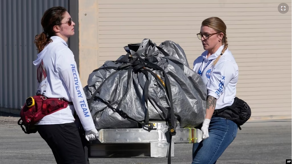 Recovery team members carry a capsule containing NASA's first asteroid samples to a temporary clean room at Dugway Proving Ground in Utah on Sunday, Sept. 24, 2023. (AP Photo/Rick Bowmer, Pool)