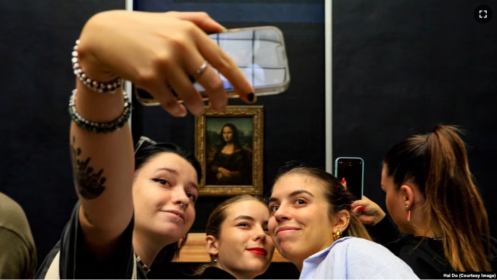 FILE - Visitors take pictures of themselves with the famous Leonardo Da Vinci's Mona Lisa at the Louvre in Paris, France on Sept. 11, 2022. (Photo by Hai Do)