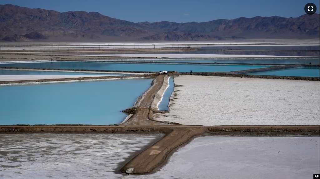 FILE - A truck is parked between brine evaporation ponds at Albemarle Corp.'s Silver Peak lithium facility, Oct. 6, 2022, in Silver Peak, Nev. (AP Photo/John Locher, File)