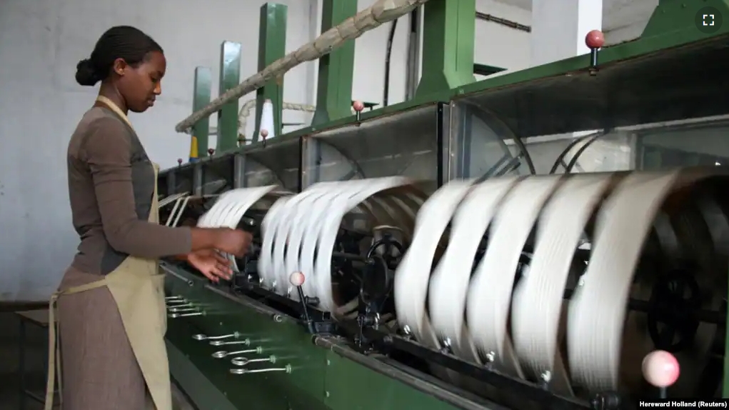 FILE - A woman spins raw silk yarn in a factory owned by Rwandan textile firm Utexwra in Kigali January 19, 2009. A recent study says African countries are less likely to follow East Asia’s development model of expanding manufacturing to reduce poverty.(REUTERS/Hereward Holland)