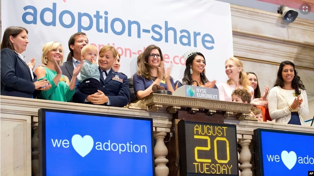 FILE - In this photo provided by the New York Stock Exchange, Adoption-Share founder and CEO Thea Ramirez, center, and supporters ring the opening bell at the New York Stock Exchange in New York on Aug. 20, 2013. (NYSE via AP)